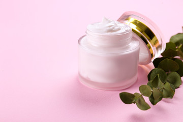 Obraz na płótnie Canvas Moisturizing care skincare face cream for healing complicated troubled skin type in an open jar with visible texture. Copy space, close up, background, flat lay, top view. Eucalyptus leaf decoration.