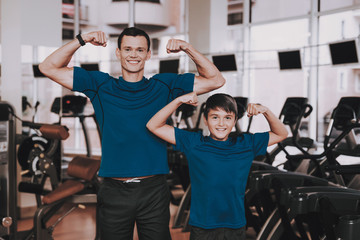 Fototapeta na wymiar Young Father and Son Preparing for Training in Gym