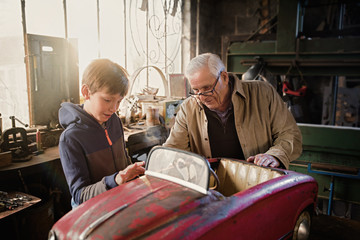 Fototapeta na wymiar A grandfather and his grandson in the DIY workshop