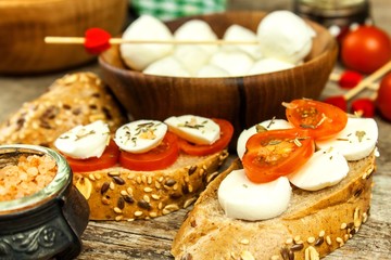 Traditional Italian Mozzarella cheese on a wooden board. Healthy cheese. Dairy products. Mozzarella cheese balls with  tomatoes. Diet food.