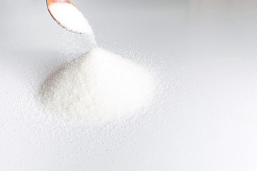 Pile of sugar sand mound with a wooden spoon.