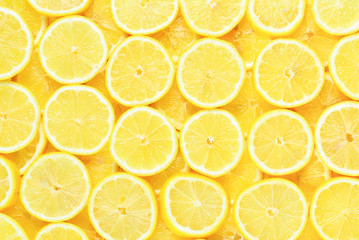 A slices of fresh juicy yellow lemons.  Texture background, pattern.