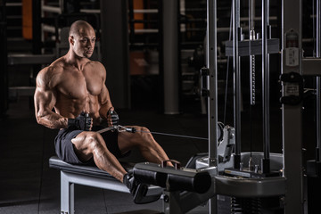 Fototapeta na wymiar Brutal strong bodybuilder athletic man pumping up muscles workout bodybuilding concept background