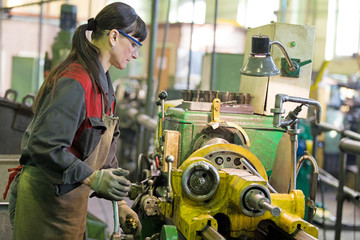 Metalwork industry. Factory woman turner working on workshop lathe machine - obrazy, fototapety, plakaty
