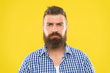 Obraz premium Bearded and serious. Beard fashion and barber concept. Man bearded rustic hipster stylish beard yellow background. Barber tips maintain beard. Stylish beard and mustache care. Hipster appearance