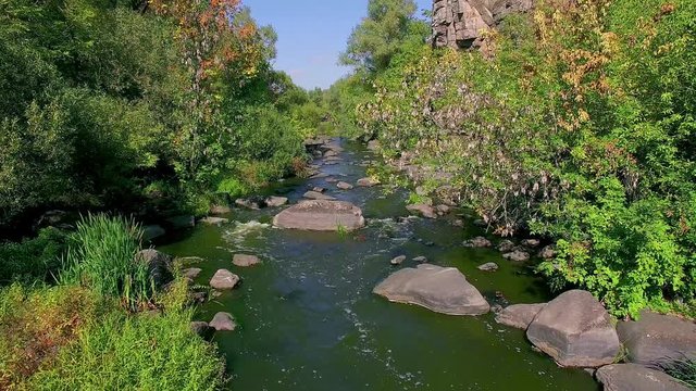 4K aerial view of autumn canyon, mountain river in canyon, River flowing among rocks in autumn, flight above the mountain river, flying over buky canyon in the autumn