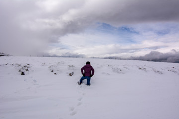 Fototapeta na wymiar woman walking through the snow in the mountains