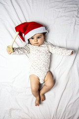 baby with santa hat playing with a wooden spoon
