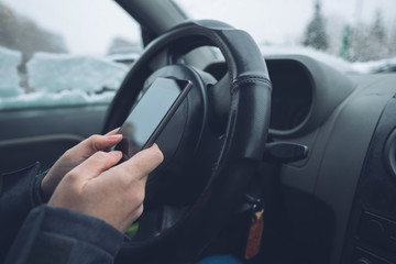 Texting in parked car while the snow is falling outside