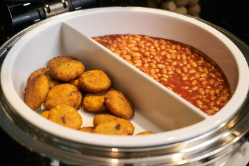 Baked beans and hash brown, close-up. Restaurant buffet catering