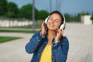 girl with headphones walking in the Park on a Sunny day and listening to music