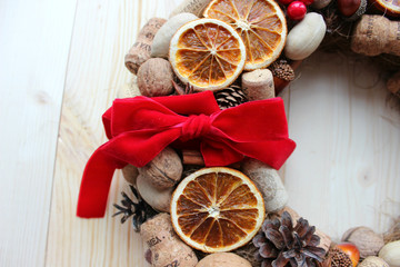 Christmas card. Background Christmas and new year. Christmas wreath of nuts, cones, dried oranges, corks of champagne, cinnamon sticks, ribbons. Christmas in a rustic style. Handmade decor. Christmas 