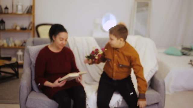 Boy gives flowers to mother