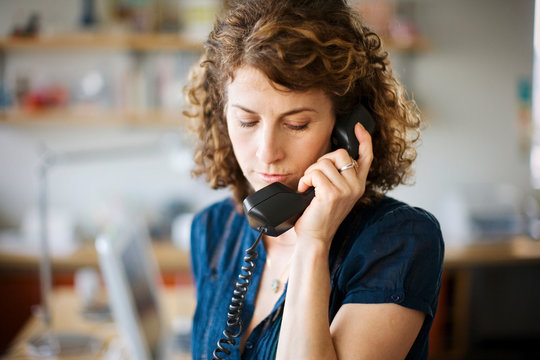 Blond Woman Talking On Landline Indoors