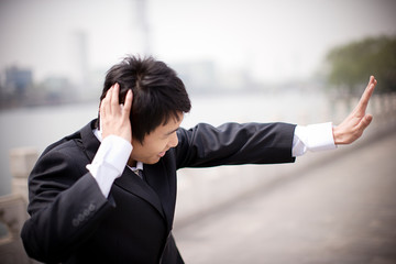 Young businessman gesturing with his hand out.