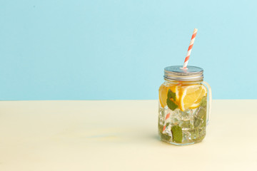 Citrus lemonade water with lemon sliced , healthy and detox water drink in summer on light-blue background