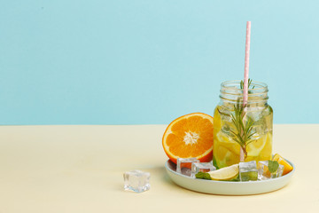 Citrus lemonade water with lemon sliced , healthy and detox water drink in summer on light-blue...