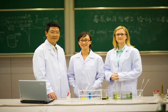 Portrait of mid-adult teachers standing in a science classroom.