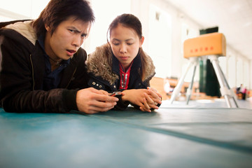 Portrait of a teenage boy and girl lying on a mat.