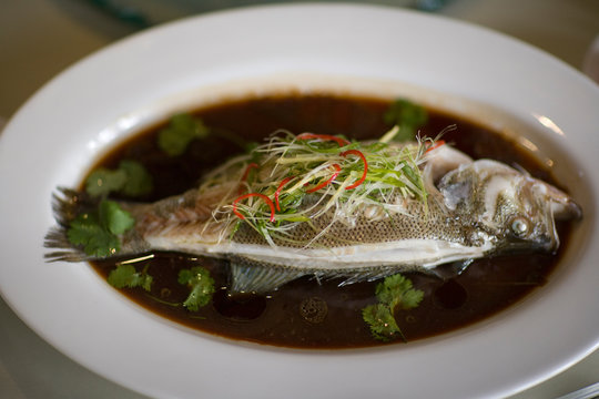 Fresh fish lying in a bowl of soup.