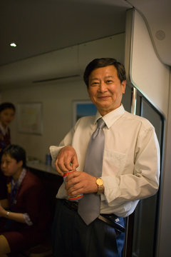 Portrait of a mature businessman drinking a beer on a train.