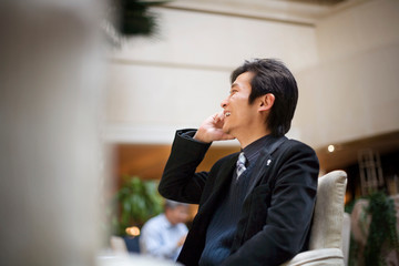 Young adult businessman using a cellphone in a cafe.