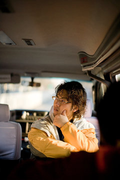 Young adult man sitting in a car.