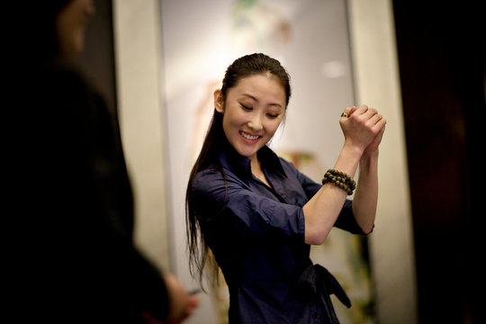 Young adult business woman dancing in an office.