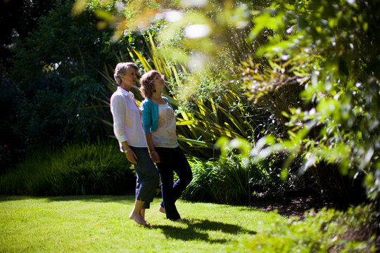 Mother and daughter walking in a garden together, admiring the plants
