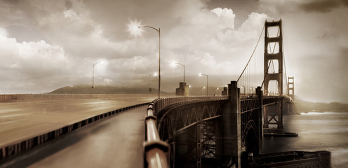 Suspension bridge underneath moody sky.