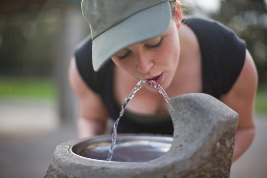 Woman drinking from water fountain