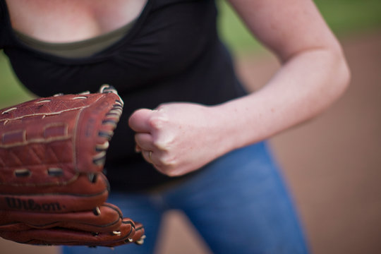 Woman standing on sport field with baseball mitt