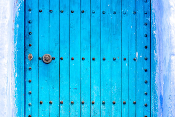 Traditional moroccan door in Chefchaouen blue city in Morocco on a sunny day