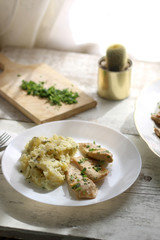 Grilled chicken with fresh parsley and mashed potatoes on a rustic white table. Selective focus.