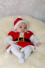 Fototapeta premium baby in santa claus hat sitting on fur
