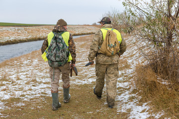 Naklejka premium Hunters with a german drathaar and spaniel, pigeon hunting with dogs in reflective vests