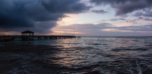 Panoramic seascape view of the Atlantic Ocean Coast during a dramatic cloudy sunrise. Taken in Key West, Florida Keys, United States.
