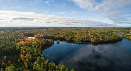 Fototapeta na wymiar Aerial panoramic view of a beautiful lake during a sunny autumn day. Taken in Charlotte Lake, Queens, Caledonia, Nova Scotia, Canada.