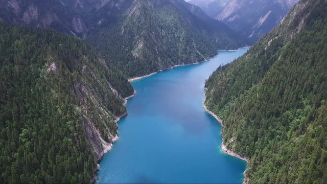 Astonishing aerial shot over a vibrant blue river between picturesque mountainside