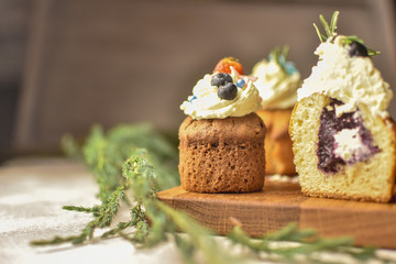 Cutted handmade capcake with blueberries on wood background top view.