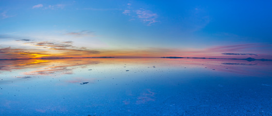 Naklejka na ściany i meble Uyuni reflections. One of the most amazing things that a photographer can see. Here we can see how the sunrise over an infinite horizon with the Uyuni salt flats making a wonderful mirror to infinity