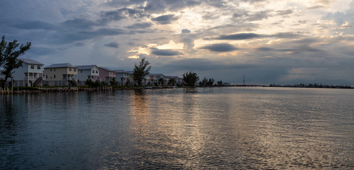 Panoramic view of residential homes on the ocean shore during a vibrant cloudy sunset. Taken in Key...