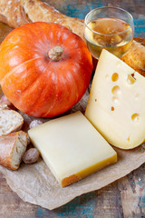 Ingrediens for traditional seasonal Swiss dish, pumpkin fondue with gruyer and emmentaler cheeses, white wine, fresh creme and bread