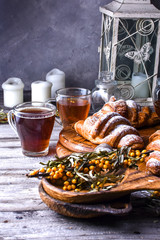 Fresh croissants sprinkled with nuts and a cup of black coffee