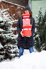 woman returning home from shopping holding pile of christmas present boxes