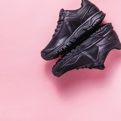 red fresh fruit smoothies, mp3 player with headphones and black sneakers on a pink background. concept of youth, music, sport and health