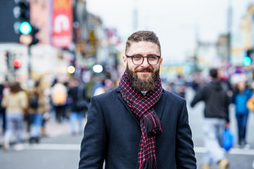 Young beard man wearing winter clothes in the street