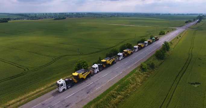 Aerial view. Transportation of combines on road tractors on the road. Oversized transportation. 4k