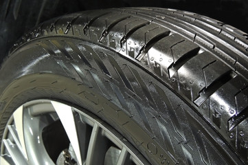 Polished sidewall of car tire on the alloy wheel rim close up 