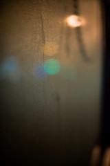 Foggy window and blurred lights